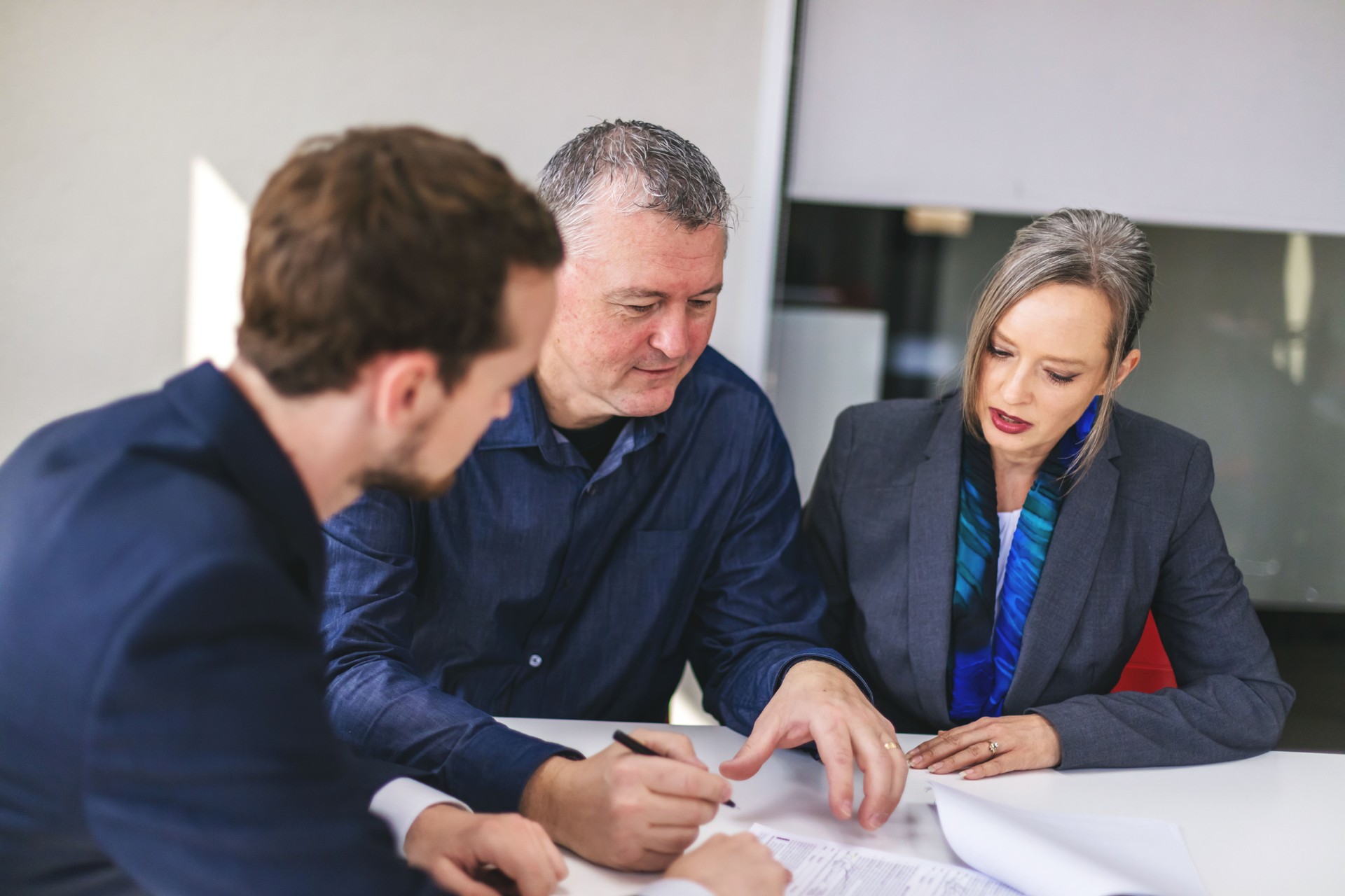 Mature Adult Husband and Wife Clients with Young Millennial Male Businessman
