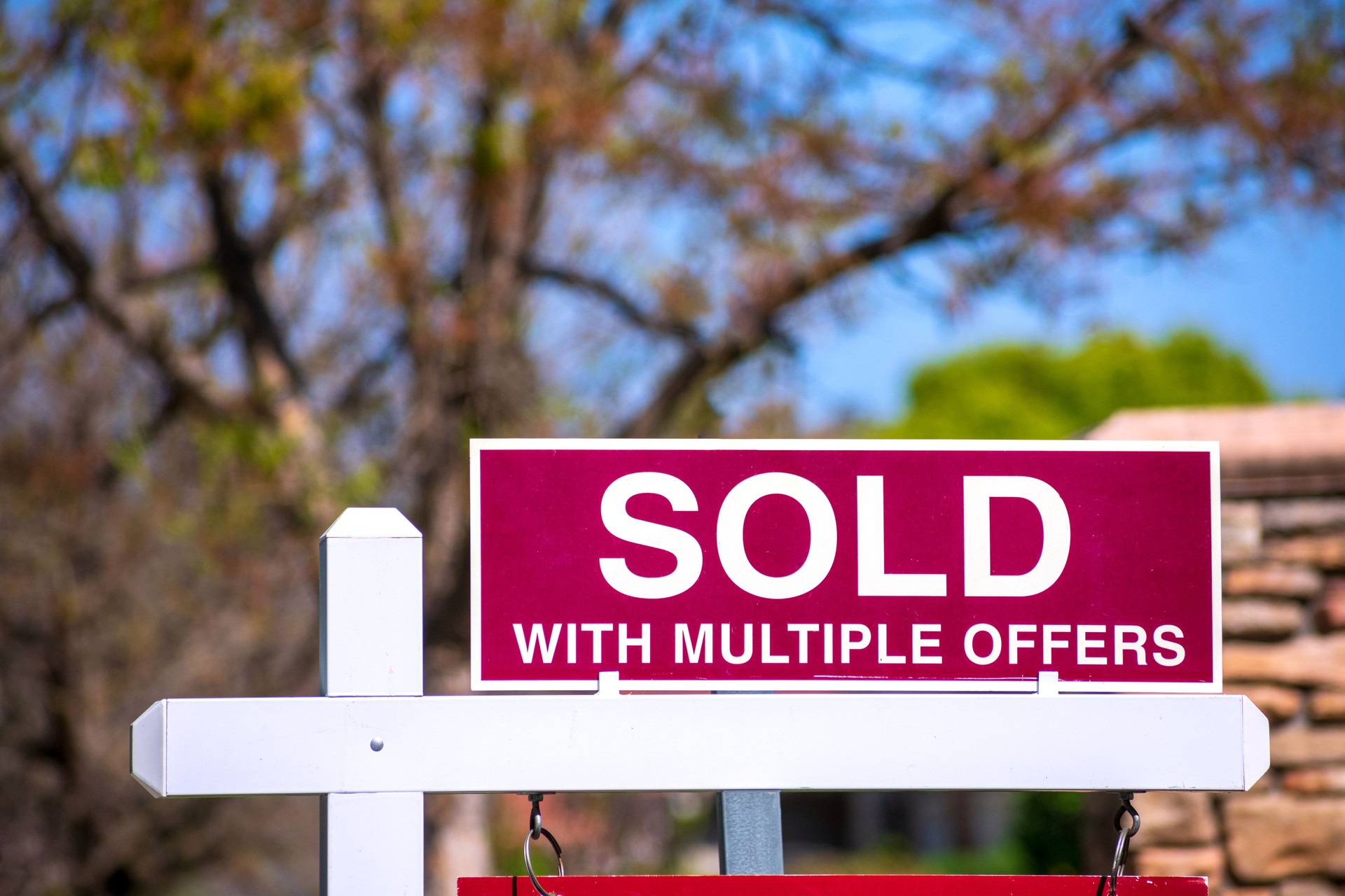 SOLD With Multiple Offers real estate sign near purchased house.
