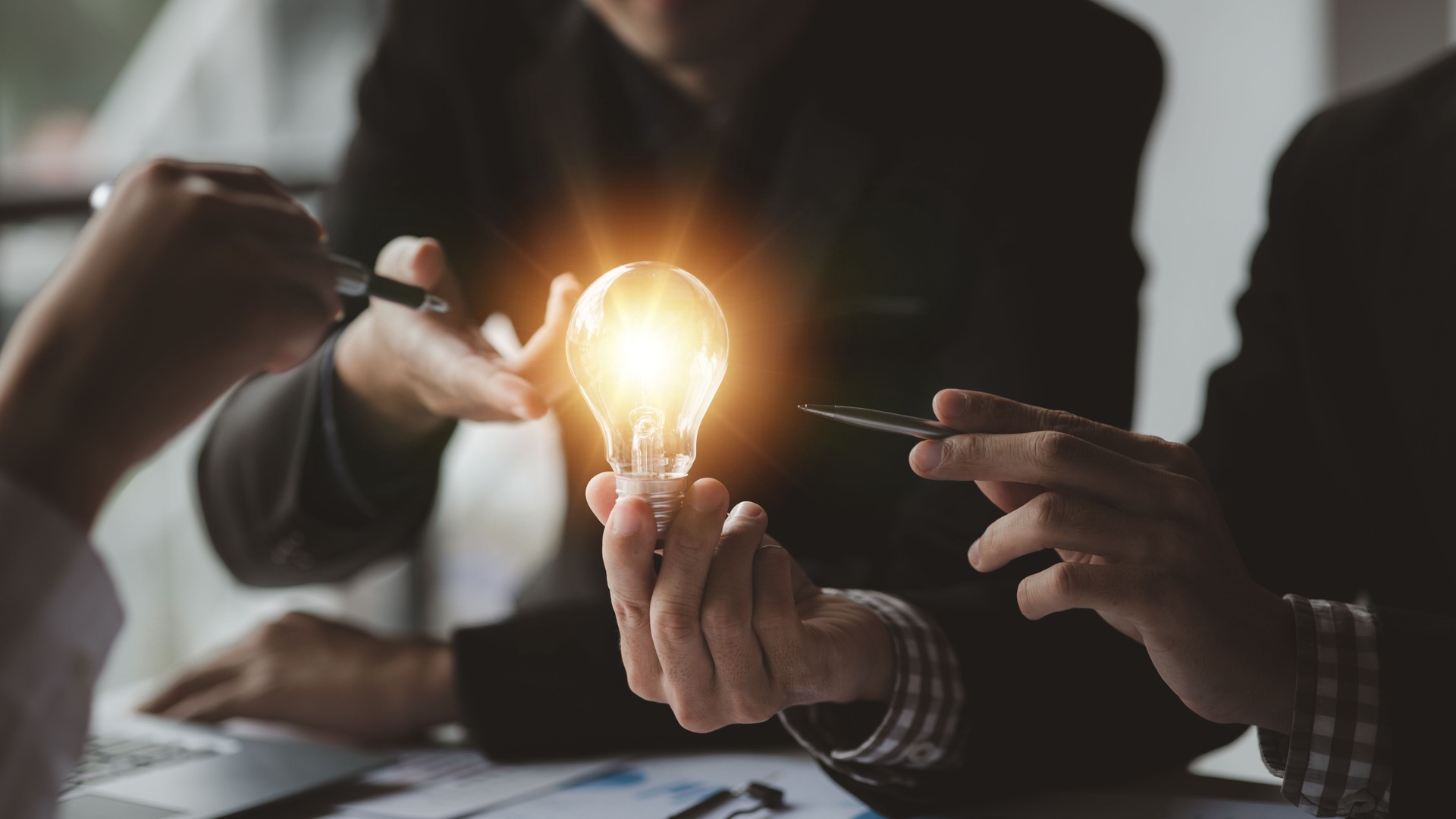 Businessman holds a glowing lamp, Creative new idea. Innovation, brainstorming, strategizing to make the business grow and be profitable. Concept execution, strategy planning and profit management.